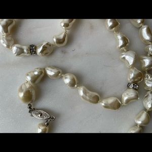 Pearl like necklace with sparkle stones in between.  24 inches long